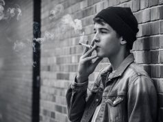 Global Tobacco Epidemic: 37 Million Children Ages 13-15 Use Tobacco, Experts Warn a-candid-black-and-white-photograph-of-a-male-teen-smiking