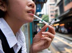 Businesses, Lawmakers Push Back Against Hong Kong’s Proposed Tobacco Control A young Asian woman smoking electronic cigarettes 002