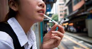 Businesses, Lawmakers Push Back Against Hong Kong’s Proposed Tobacco Control A young Asian woman smoking electronic cigarettes 002
