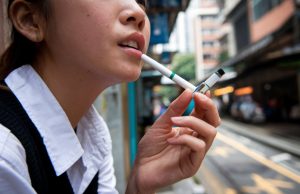 Businesses, Lawmakers Push Back Against Hong Kong’s Proposed Tobacco Control A young Asian woman smoking electronic cigarettes 002