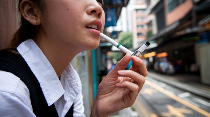 Businesses, Lawmakers Push Back Against Hong Kong’s Proposed Tobacco Control A young Asian woman smoking electronic cigarettes 002